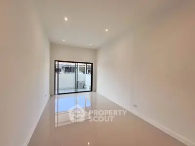 Spacious modern living room with large windows and glossy tiled floor.
