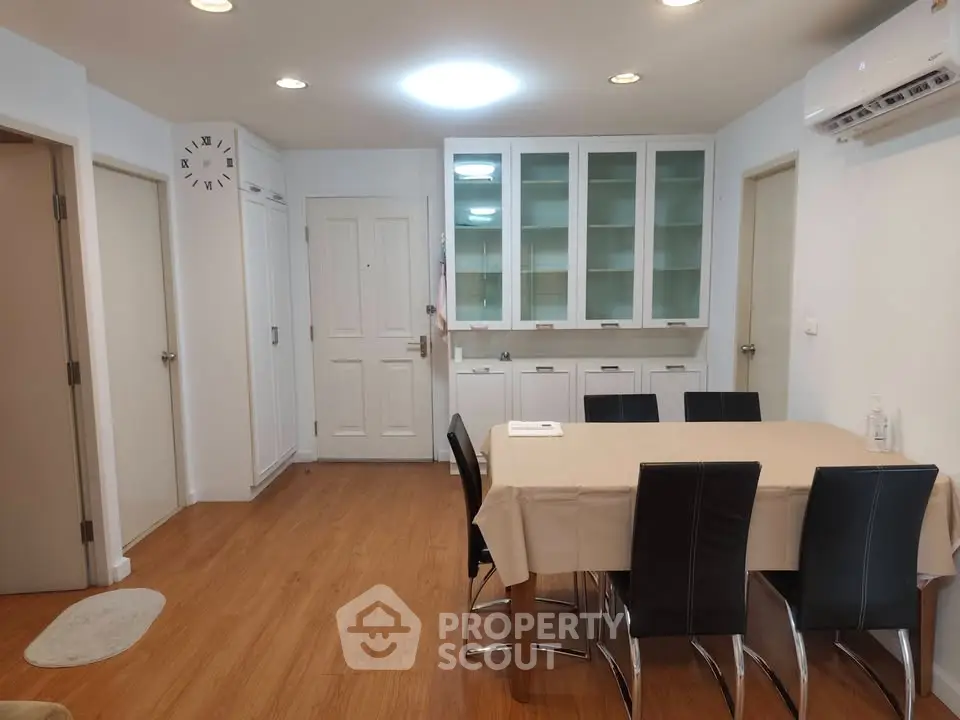 Spacious dining area with modern furniture and built-in storage in a stylish apartment.