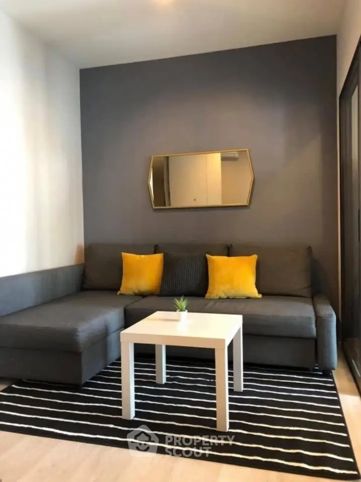 Modern living room with stylish gray sofa, yellow cushions, and chic decor in a cozy apartment.