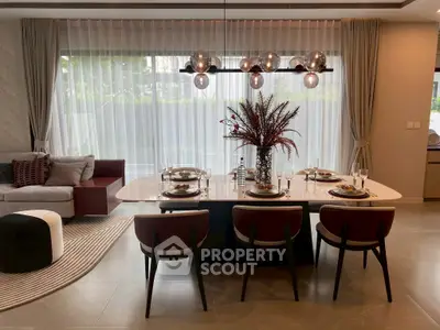 Elegant dining area with modern chandelier and stylish table setting in luxurious home.