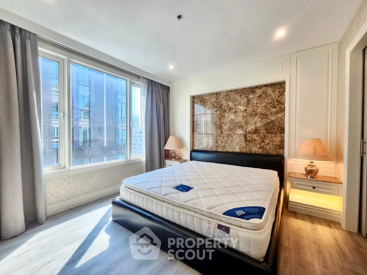 Luxurious bedroom with large windows and elegant decor in a modern apartment.