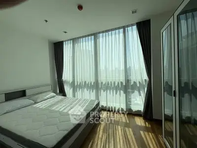 Spacious bedroom with large windows and natural light in modern apartment