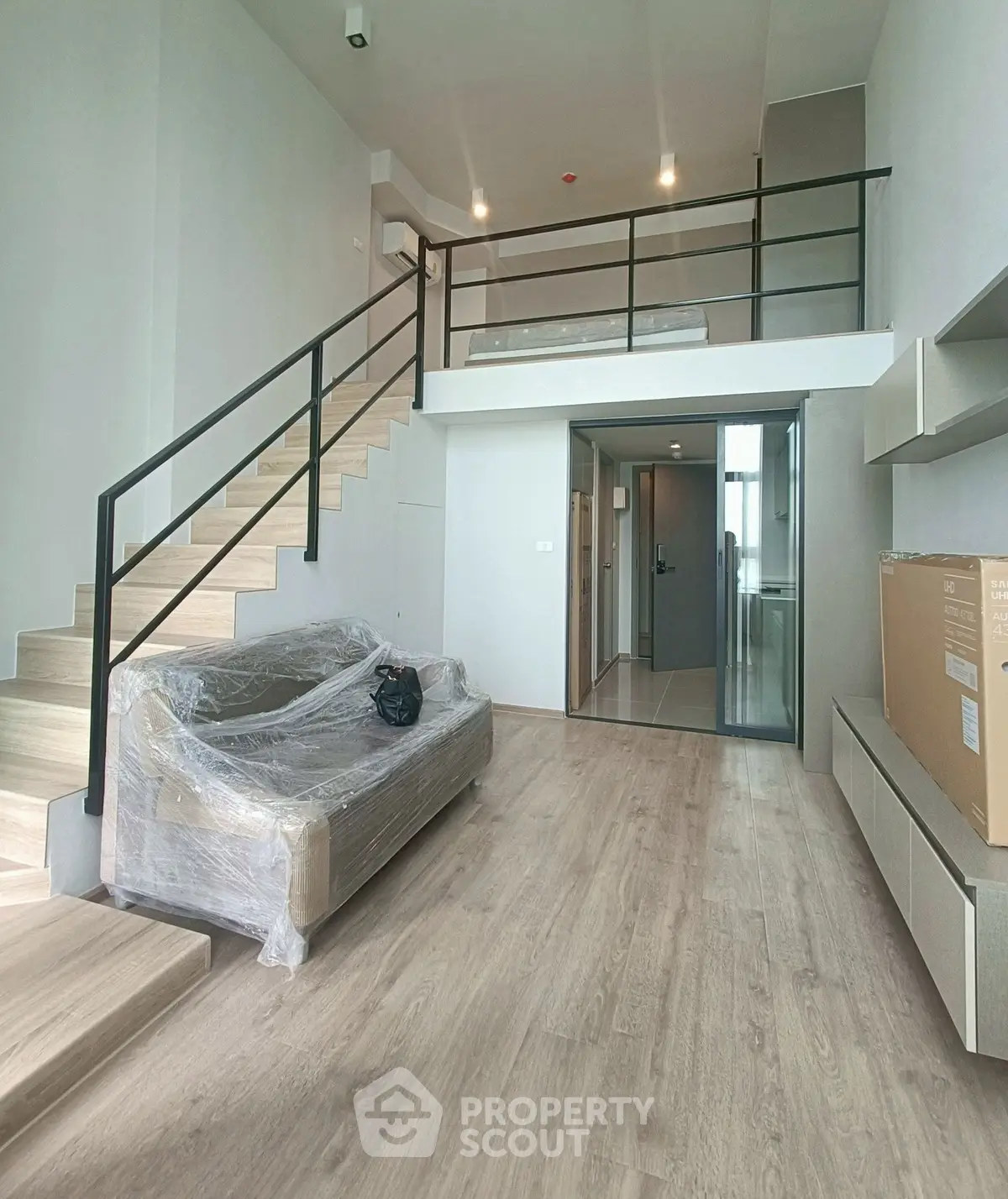 Modern loft-style living room with mezzanine and sleek staircase