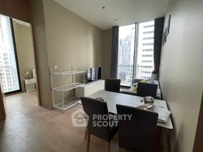 Modern living room with dining area and city view balcony in high-rise apartment.