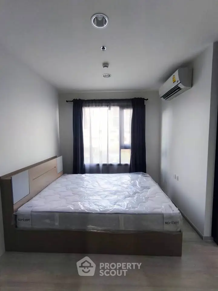 Modern bedroom with large window and air conditioning in a stylish apartment.