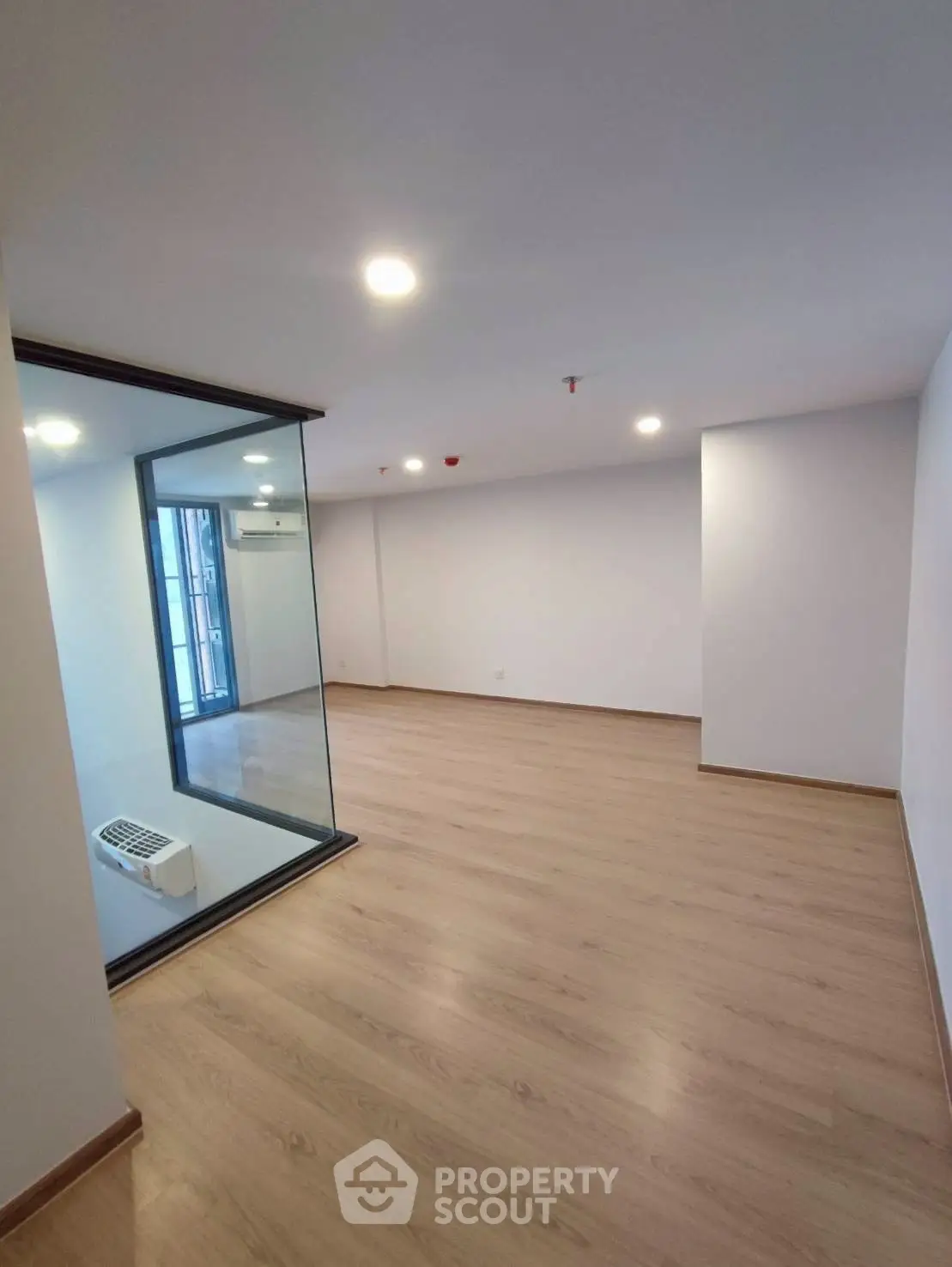 Spacious modern living room with wooden flooring and glass partition