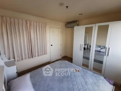 Cozy bedroom with mirrored wardrobe and air conditioning in modern apartment.