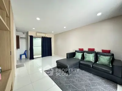 Spacious living room with modern decor and large sectional sofa in a bright apartment.