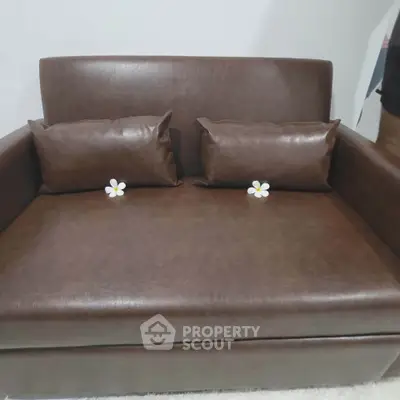 Luxurious brown leather loveseat with plush cushions in modern living room.