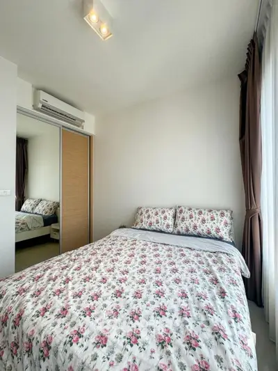Cozy bedroom with floral bedding and mirrored closet doors