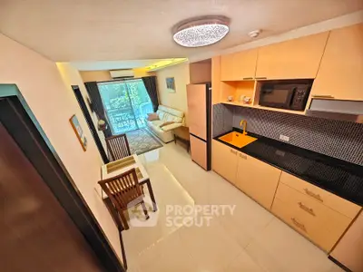 Modern open-layout kitchen and living room with balcony view in a stylish apartment.