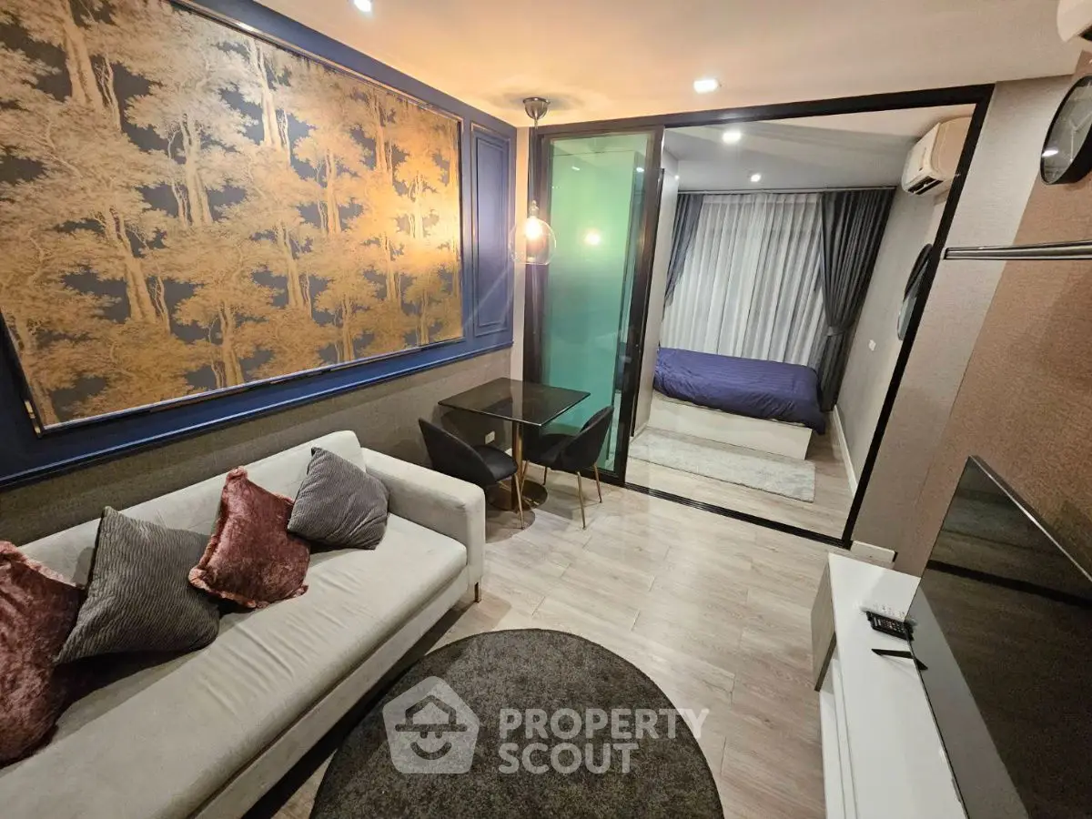 Modern living room with elegant decor and glass partition to bedroom