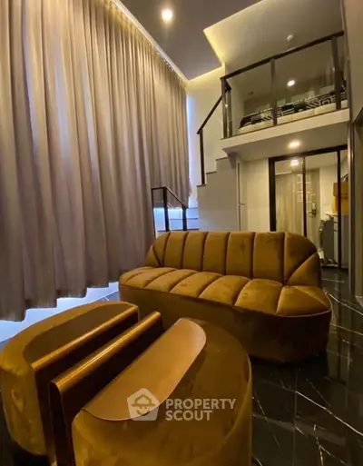 Luxurious modern living room with plush velvet furniture and elegant staircase in a stylish apartment.