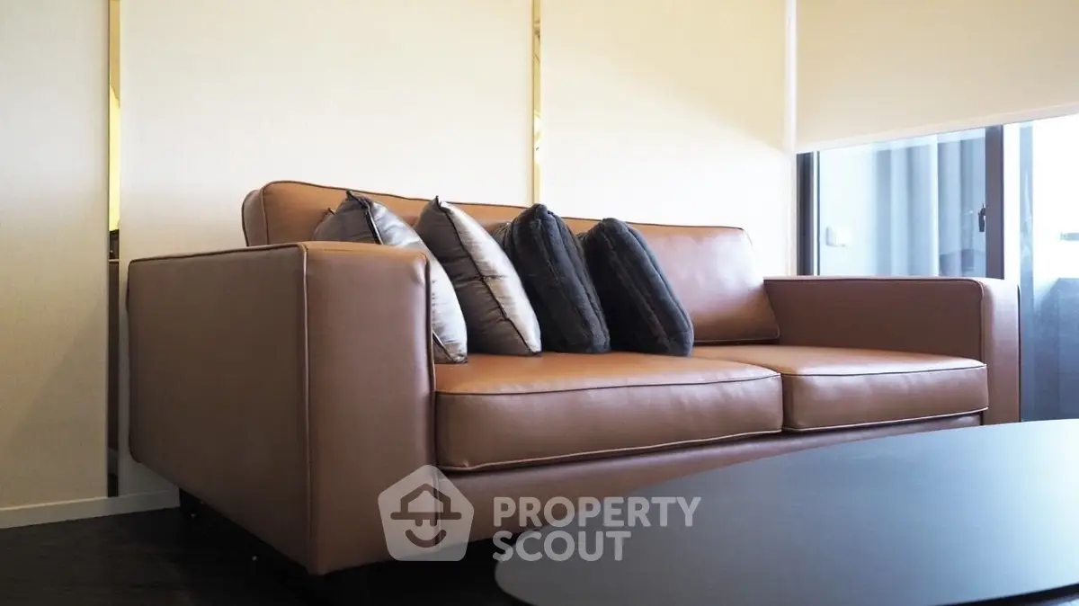 Stylish modern living room with elegant brown leather sofa and plush cushions, perfect for relaxation.