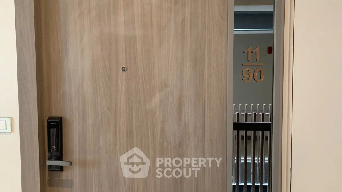 Modern apartment entrance with electronic lock and stylish wood finish.