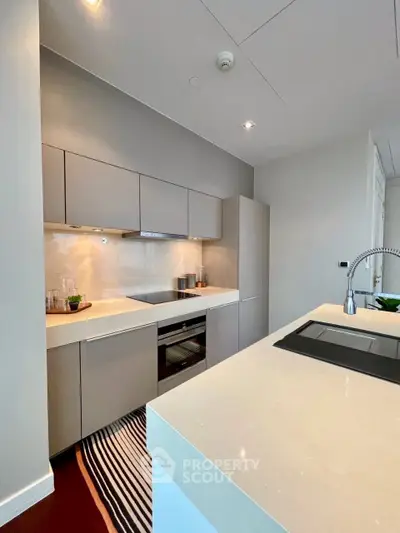 Modern kitchen with sleek cabinetry and integrated appliances in a stylish apartment.