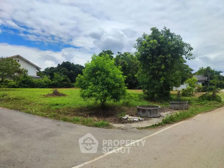 Spacious plot of land with lush greenery and clear skies, ideal for development.