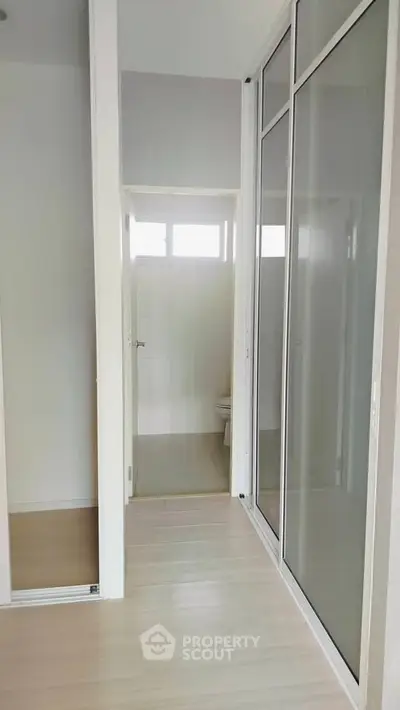 Modern minimalist bathroom with sliding glass doors and natural light