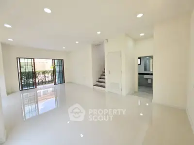 Spacious modern living room with glossy floors and large windows for natural light.