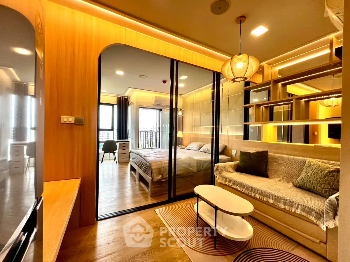 Modern apartment interior with cozy living room and stylish bedroom separated by glass wall.