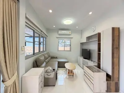 Modern living room with sleek furniture and natural light, perfect for relaxation and entertainment.