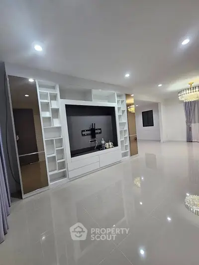 Spacious modern living room with built-in entertainment center and elegant lighting