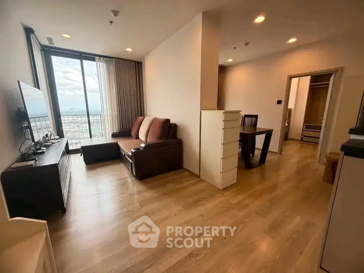 Spacious living room with city view and modern furnishings in high-rise apartment