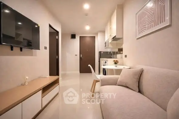 Modern living room with sleek furniture and open kitchen layout in a stylish apartment.