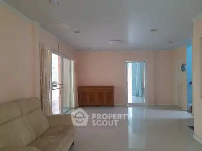 Spacious living room with beige sofa and large windows for natural light.