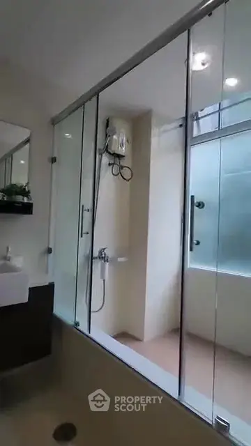 Modern bathroom with glass shower enclosure and sleek fixtures