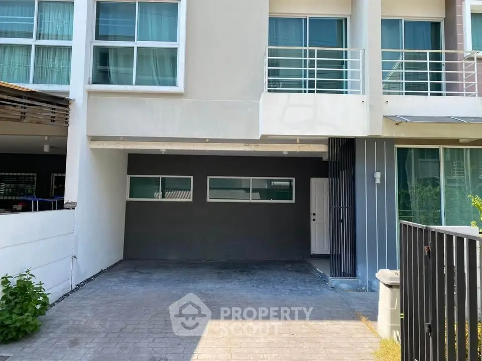 Modern townhouse exterior with spacious driveway and large windows