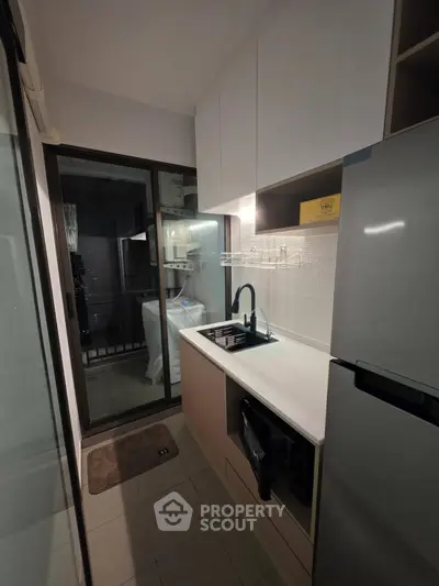 Modern compact kitchen with sleek design and balcony access