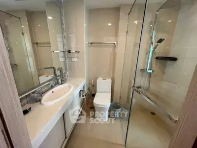 Modern bathroom with glass shower and sleek fixtures in a contemporary apartment.