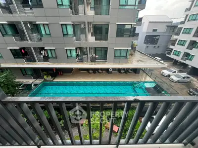 Modern apartment building with a pool view from balcony, showcasing urban living amenities.
