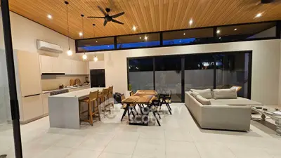Modern open-plan living room and kitchen with stylish decor and wooden ceiling