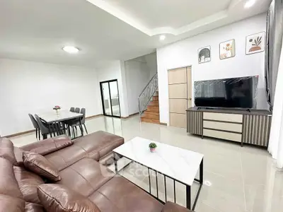 Spacious living room with modern decor, leather sofa, and dining area in open layout.
