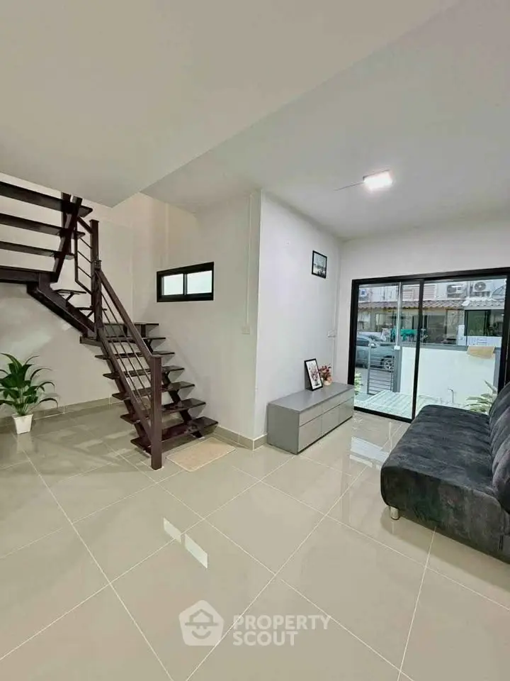 Modern living room with sleek staircase and large window view