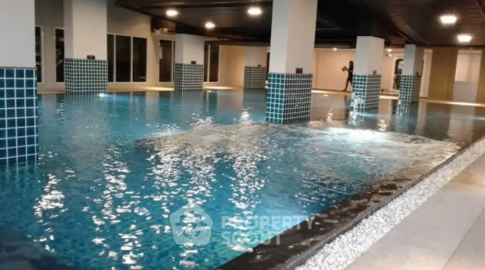Luxurious indoor swimming pool with modern design and ambient lighting in a high-end residential building.