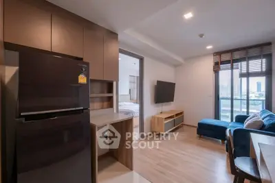 Modern open-plan living room with kitchen and balcony view in a stylish apartment.