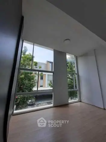 Spacious room with large windows offering natural light and urban view.