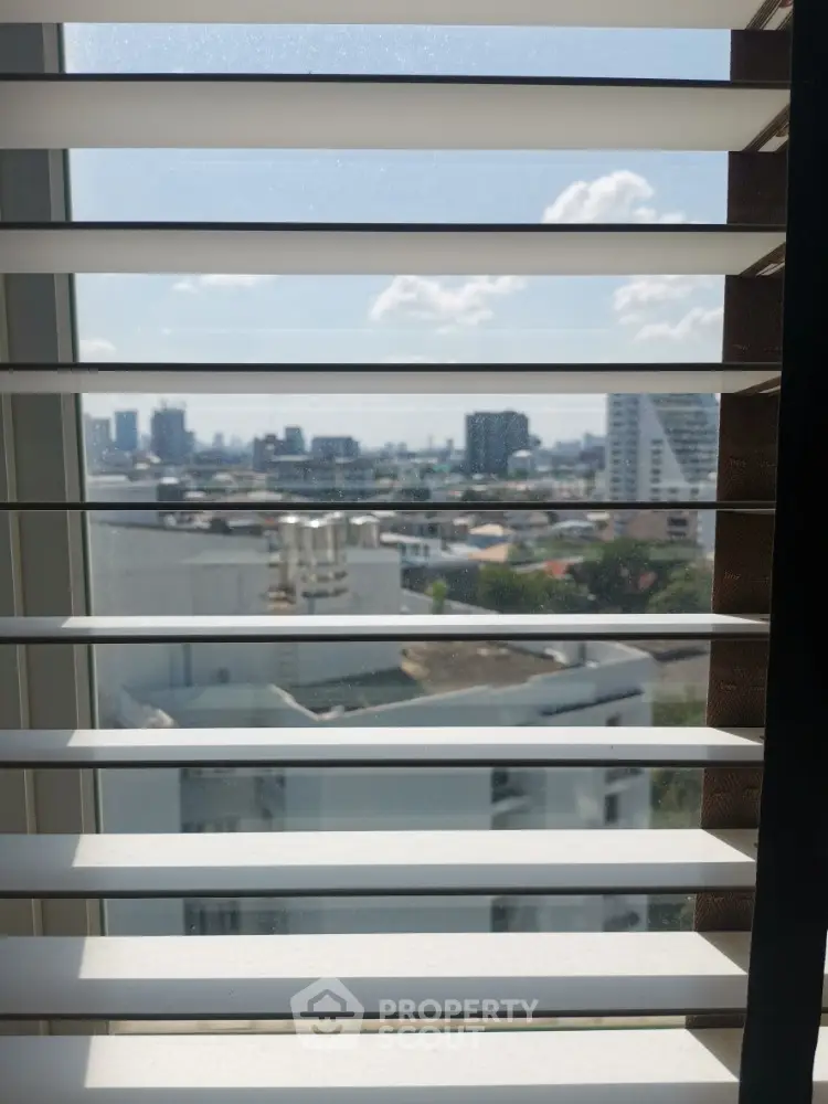 Cityscape view through window blinds in modern apartment