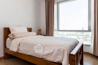 Cozy bedroom with large window offering stunning city views, featuring wooden bed and elegant curtains.