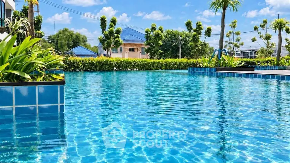 Luxurious outdoor swimming pool with crystal-clear water and lush greenery, perfect for relaxation and leisure.