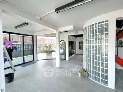Spacious modern interior with glass block wall and large windows, ideal for versatile living or office space.