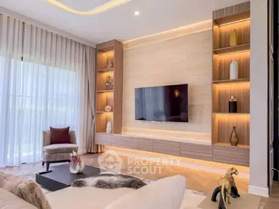 Luxurious living room with modern decor, built-in shelves, and large TV, perfect for relaxation.