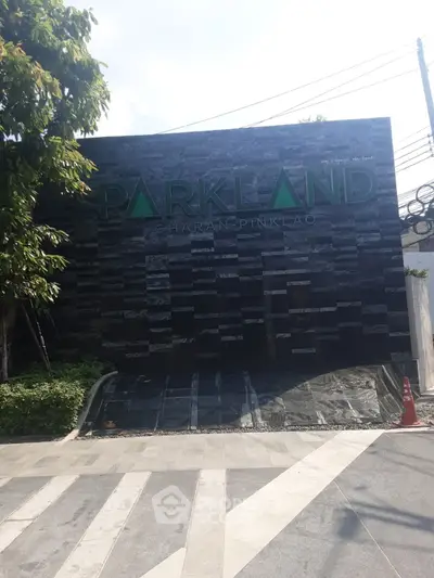 Modern building entrance with sleek design and prominent signage in urban setting.