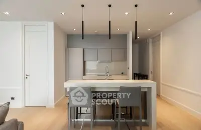 Modern kitchen with sleek design and island seating in a contemporary apartment.