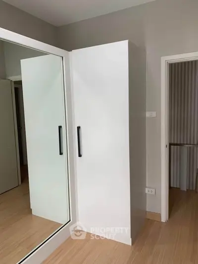 Modern minimalist wardrobe with mirrored sliding doors in a stylish bedroom.