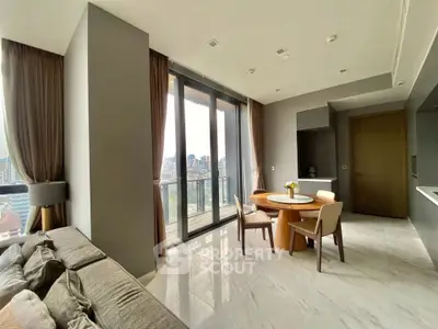 Modern living room with large windows and city view, featuring elegant furniture and a cozy dining area.