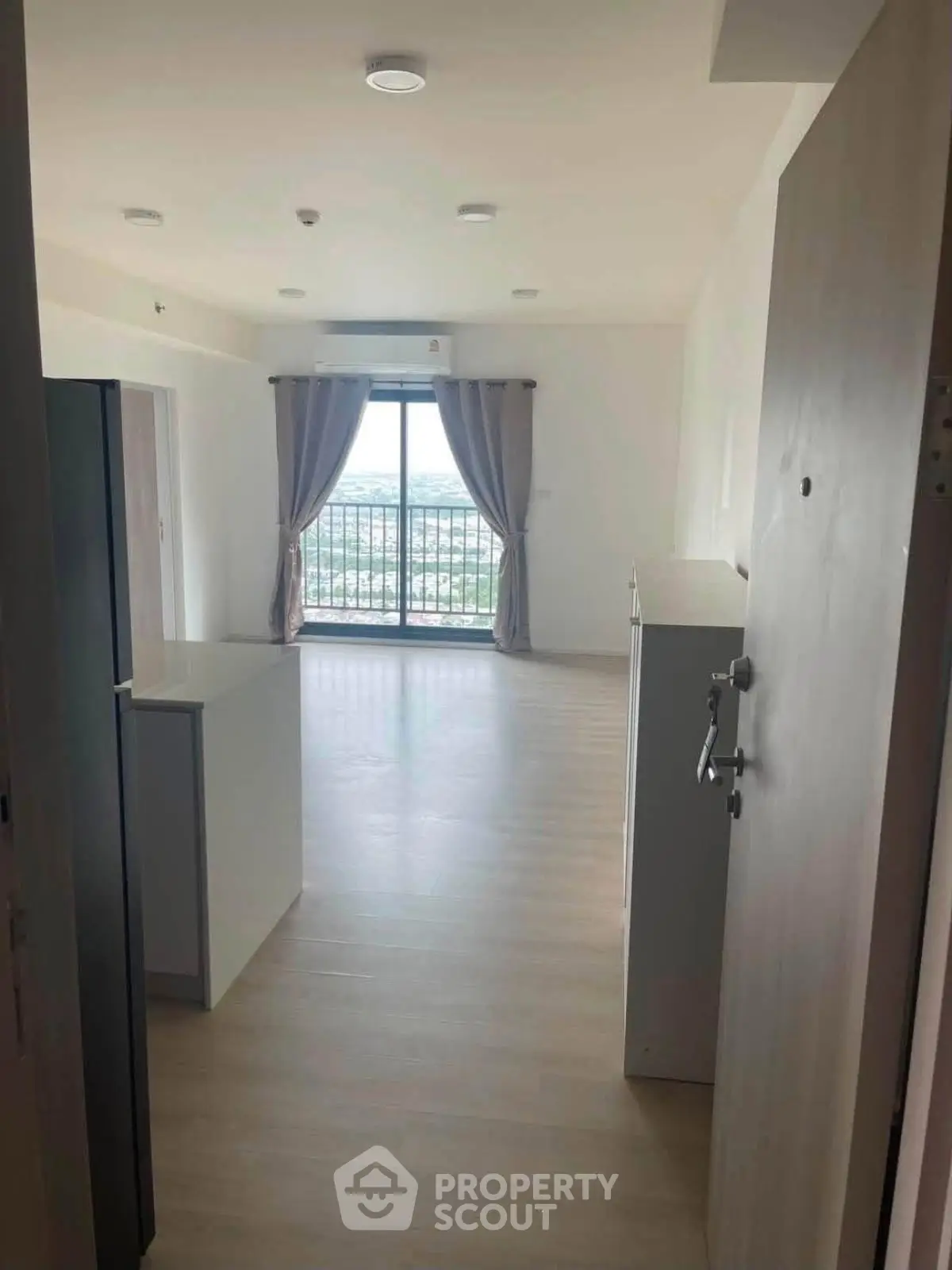 Spacious open-plan living room with large windows and balcony offering stunning views.